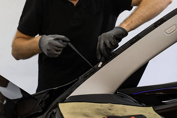 istock Removing residual adhesive after windshield removal. Technician scrapes off residual adhesive after windshield removal. Clean removal of glue is vital for correct windshield resealing. 2226371670