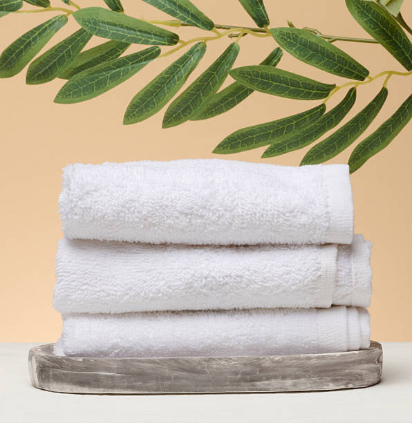 istock A stack of white folded towels lies on a marble stand, beige background 2226372057