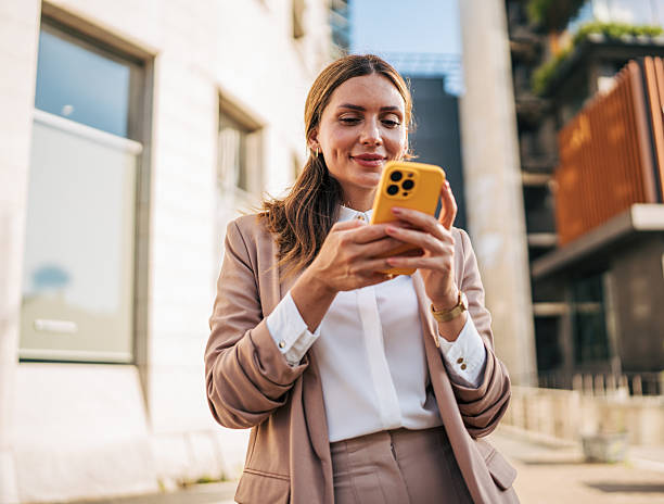 istock Smiling businesswoman using smartphone in urban setting 2226376256