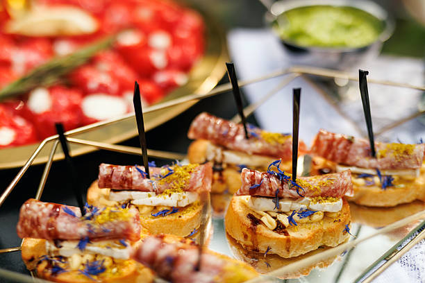 Elegant appetizer tray with salami canapes on mirrored surface