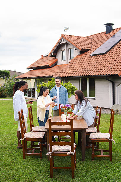 istock Friends arranging garden table, sharing laughter while preparing outdoor dining setup with vibrant summer atmosphere 2226379494