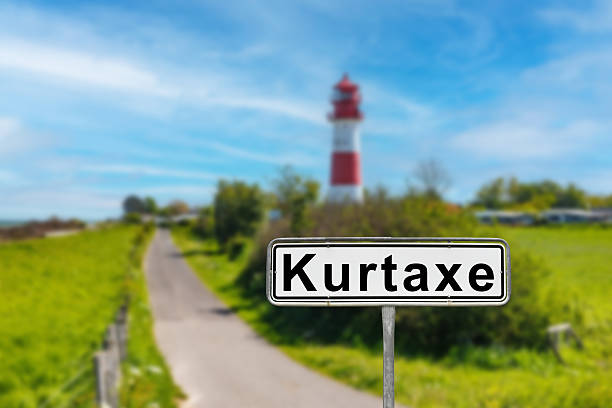 Kurtaxe road sign welcomes visitors driving to kurtaxe, germany, with its characteristic lighthouse in the background
