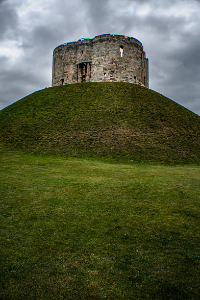 Clifford's Tower on the top of a grassy hill in the town of York, England.  Built in the 13th century, Clifford's Tower is the largest remaining piece of York Castle.
