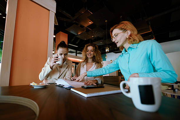 istock Businesswomen collaborating in a modern meeting space while enjoying coffee and discussing plans during a productive afternoon work session 2226383523