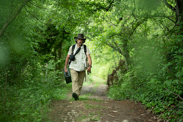 istock Environmental Scientist Walks In Green Forest Carrying Equipment 2226383705