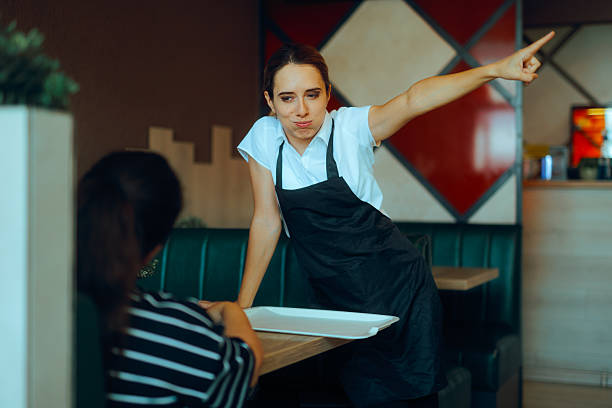 A waitress sitting bored on the counter of a 1950s styled diner.