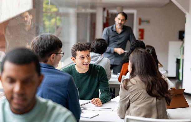 istock Happy student studying in the library with a group of friends 2226385935