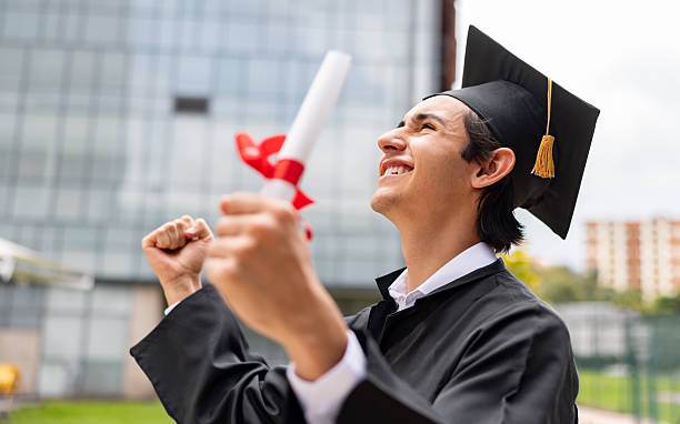 istock Student celebrating on his graduation day while holding his diploma 2226385947