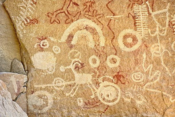 Close up of colourful animal rockpaintings of llamas and handprints on rockwalls at Cueva de las Manos, UNESCO World Heritage Site, Patagonia, Argentina