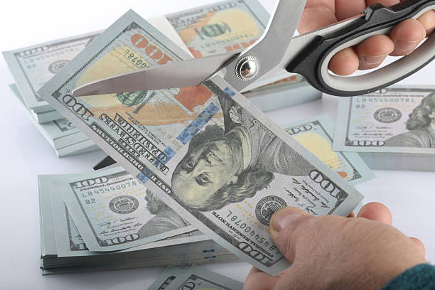 istock scissors and money on white background 2226386311