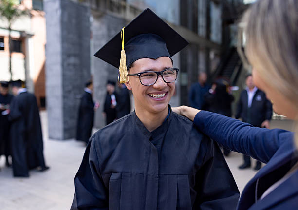 istock Happy student smiling while his mother is congratulating him on his graduation 2226386402