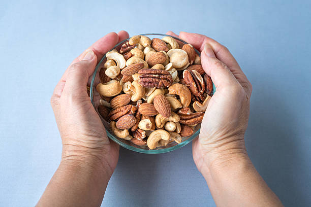 istock Hand holding a bowl of healthy nuts 2226388664
