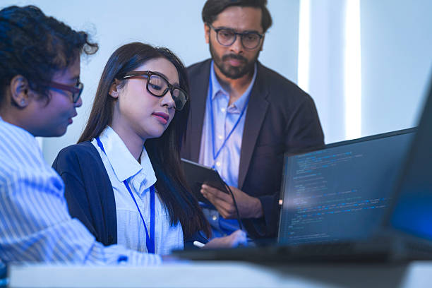 istock A senior tech lead or manager mentoring a diverse team of junior developers in a modern office. Concept for project management, corporate training, and professional growth. 2226389395