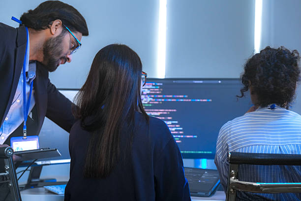 istock A senior tech lead or manager mentoring a diverse team of junior developers in a modern office. Concept for project management, corporate training, and professional growth. 2226389851