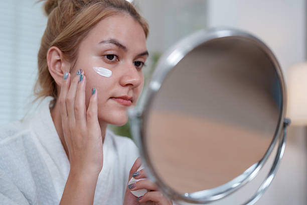 istock Enhance skin health and beauty with daily routine that helps brighten complexion while applying nourishing cream in front of mirror 2226390628
