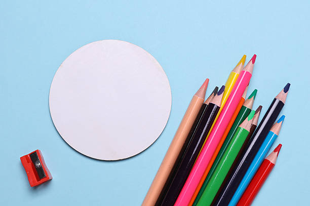 istock Set of wooden colored pencils with sharpener and white blank circle canvas on blue background 2226400148