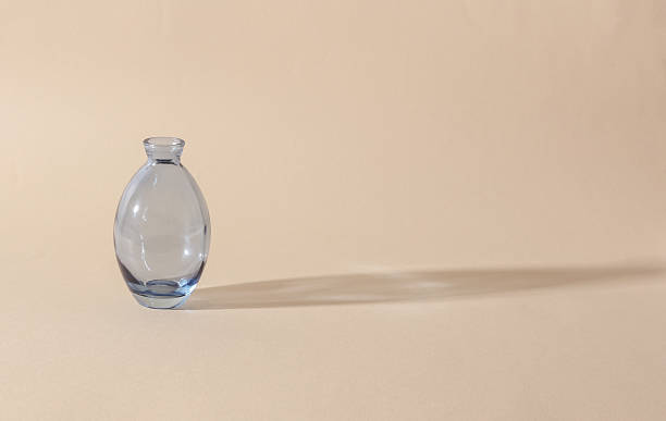 istock Glass vase on a beige background with shadow from sunlight. Minimalistic aesthetic still life. 2226400198