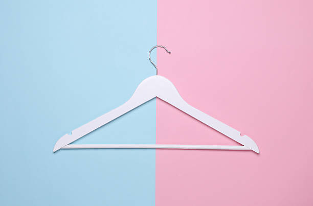 istock White wooden hanger on pink blue background. Top view 2226400252