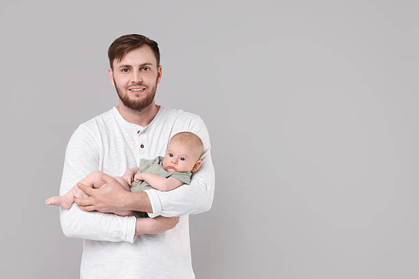 istock Father with his cute baby on grey background, space for text 2226403408