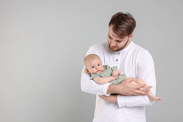 istock Father with his cute baby on grey background, space for text 2226403424