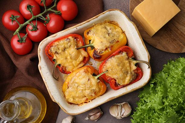 istock Delicious stuffed peppers in baking dish and ingredients on brown table, flat lay 2226404120