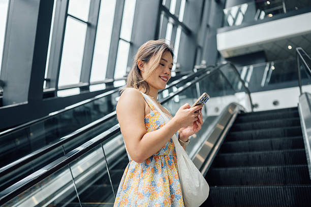 istock Using phone on an escalator to metro station 2226406051