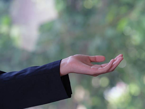 istock An empty woman's hand holding onto a green natural background. 2226406552