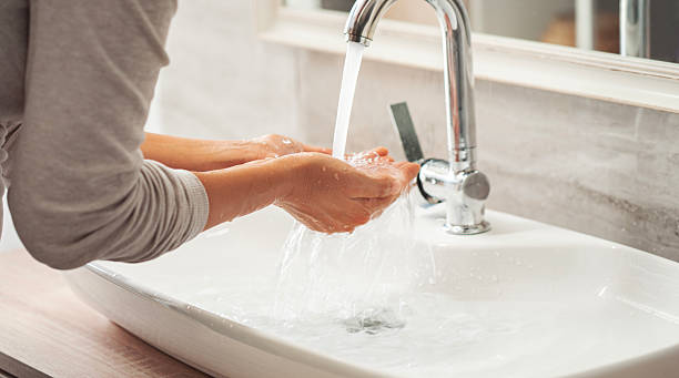 istock Woman washing her hands in the bathroom 2226408419
