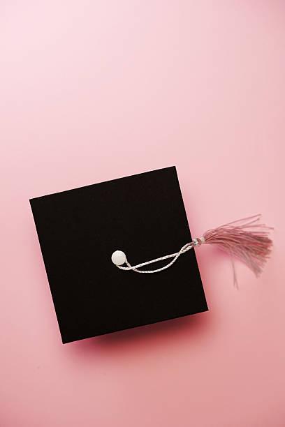 Top view of small mortarboard against pink background