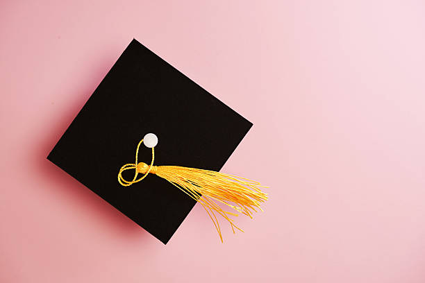 Top view of small mortarboard against pink background