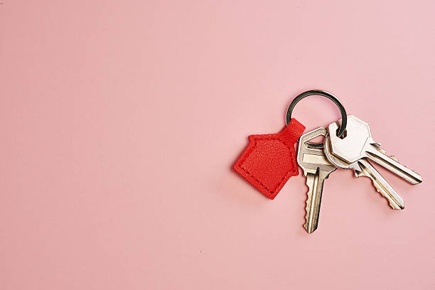 red house shape key ring against pink background