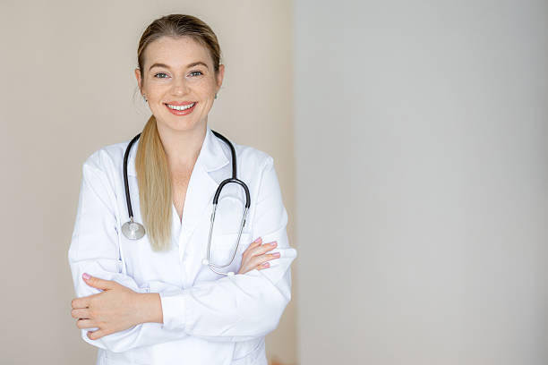 istock Confident female doctor smiling while standing with folded arms in medical uniform 2226412381