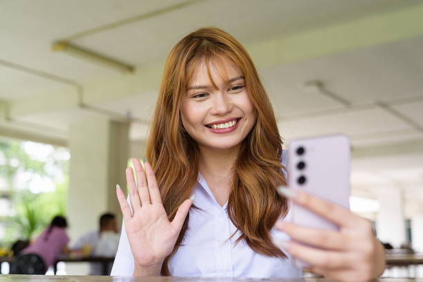 istock Thai University Student Sitting Alone at Campus Cafe Outdoors Using Phone 2226414400