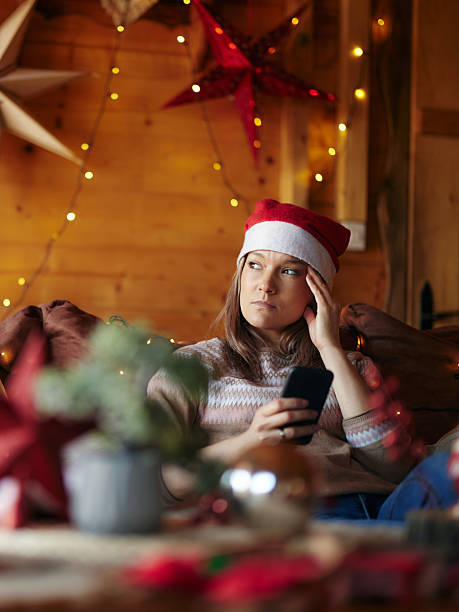 istock Displeased woman using cell phone on Christmas day at home. 2226415049