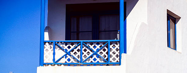 istock White painted house with wooden blue balcony and windows frame. 2226416968