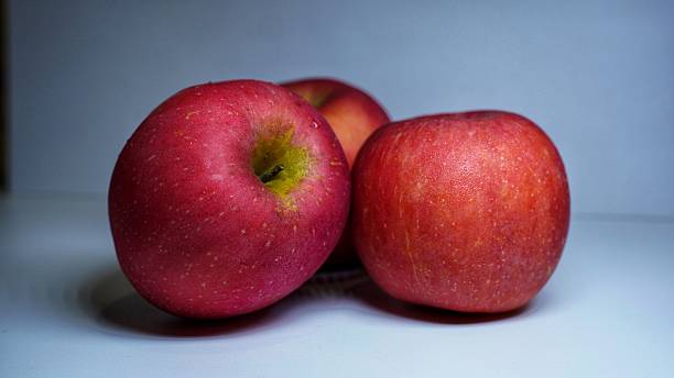 istock A close-up of three ripe red apples on a white surface. The smooth, vibrant fruit is captured in a simple studio setting, emphasizing its fresh and healthy qualities 2226417433