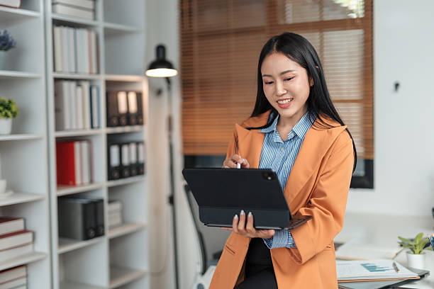 istock Young Asian businesswoman using tablet in modern office 2226417843