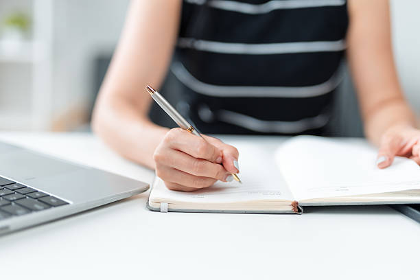 istock Businesswoman writing notes in notebook at office desk 2226418940