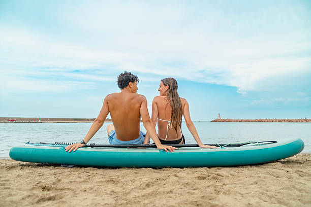 istock Couple relaxing on paddle board at the beach 2226419027