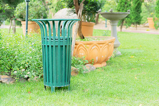 Oversized green waste container steel garbage bins for separate waste collection in public city park. Environmental care.