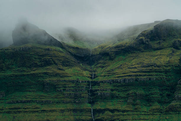 Scenic view of secluded  waterfall covered with clouds in Iceland