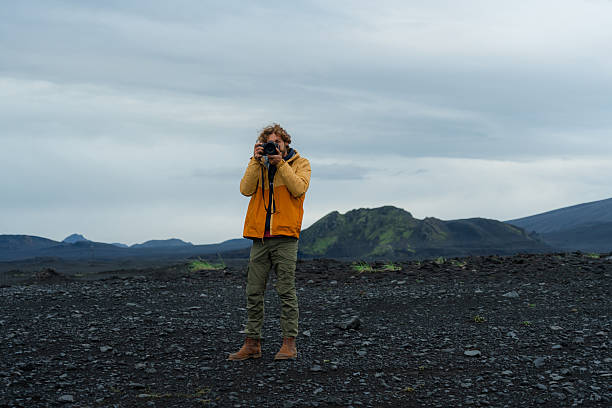 istock Man with camera exploring  volcanic landscape in Iceland 2226421712