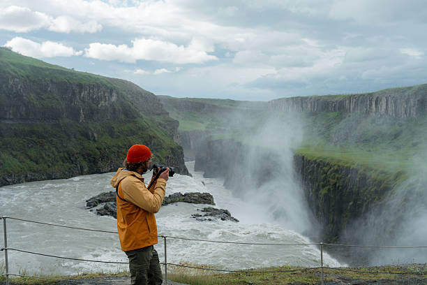 istock Man with camera  looking with awe at Gullfoss waterfall in Iceland 2226421713