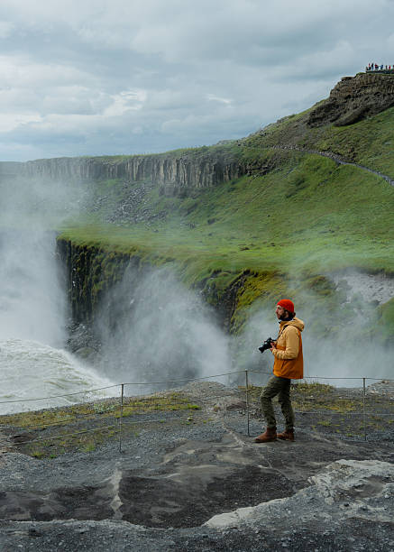 istock Man with camera  looking with awe at Gullfoss waterfall in Iceland 2226421781