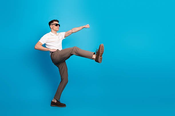istock Stylish young man wearing sunglasses and summer attire posing dynamically against a bright blue background 2226421942