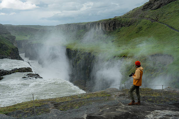 istock Man with camera  looking with awe at Gullfoss waterfall in Iceland 2226422303