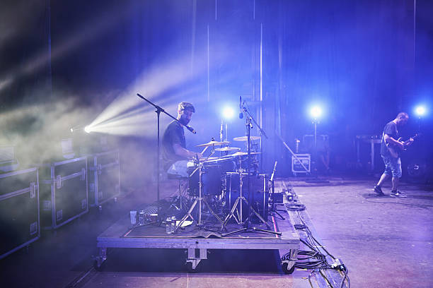 istock Drummer and guitarist performing live on stage with dramatic lighting and fog 2226425132