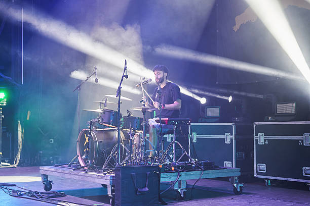 istock Drummer performing live on stage with microphone and stage lighting effects 2226425140