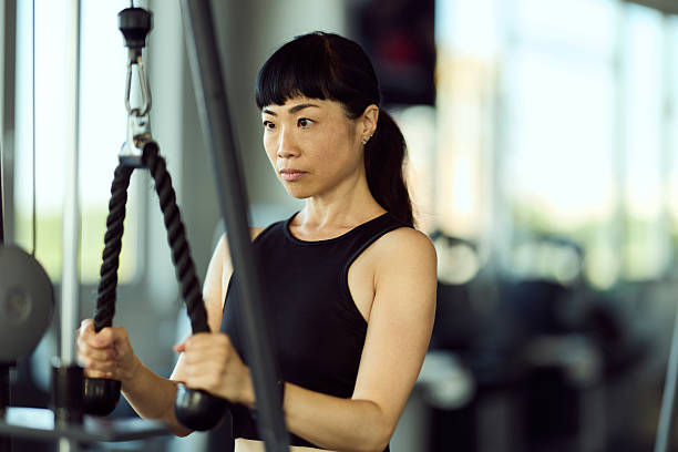 istock Focused Woman Using Cable Machine for Strength Training in Modern Fitness Studio 2226425789