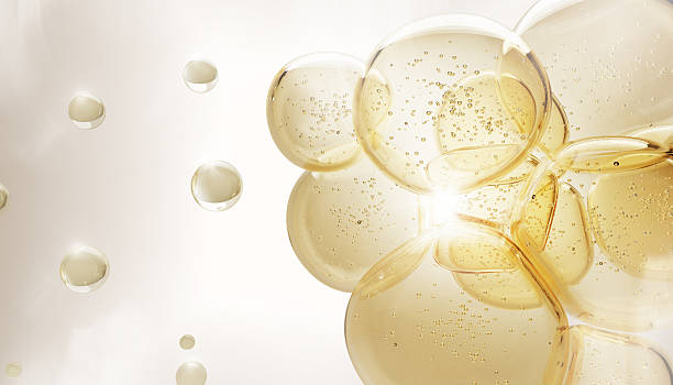 istock 3d background with oil drops texture, omega bubbles, gold liquid transparent droplets. Cosmetic skin care product, serum, collagen gel, hyaluronic essence. Honey or yellow water balls 2226430090